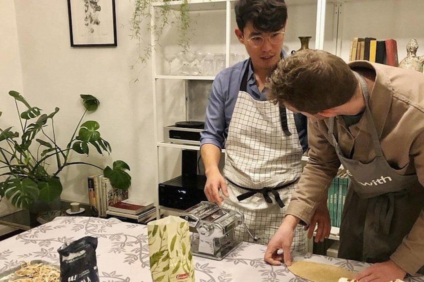 Zwei Personen bereiten Essen zu, mit Küchenutensilien und Zutaten auf dem Tisch. 4