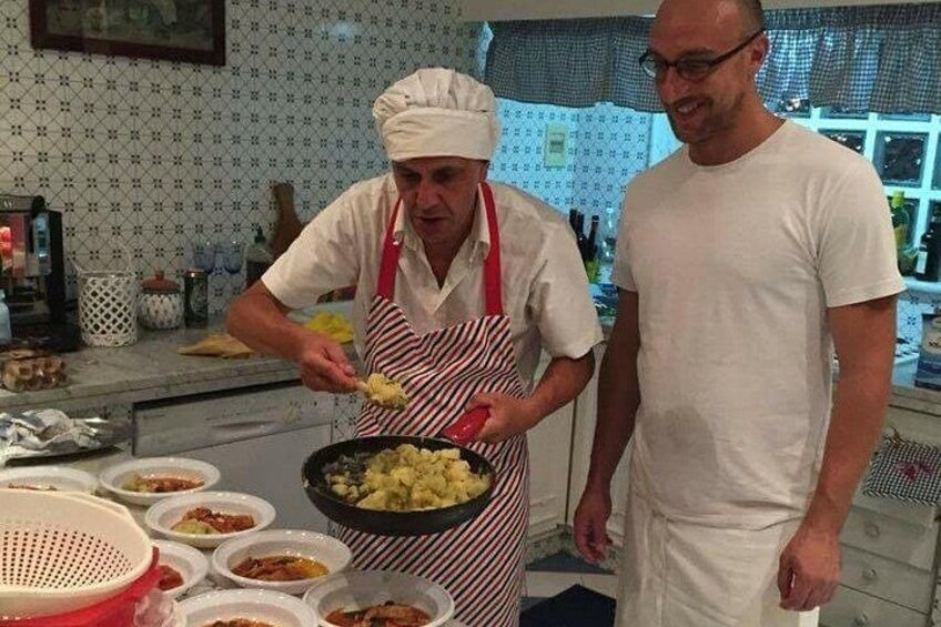 Un chef preparando comida en una cocina con varios platos e ingredientes. 2