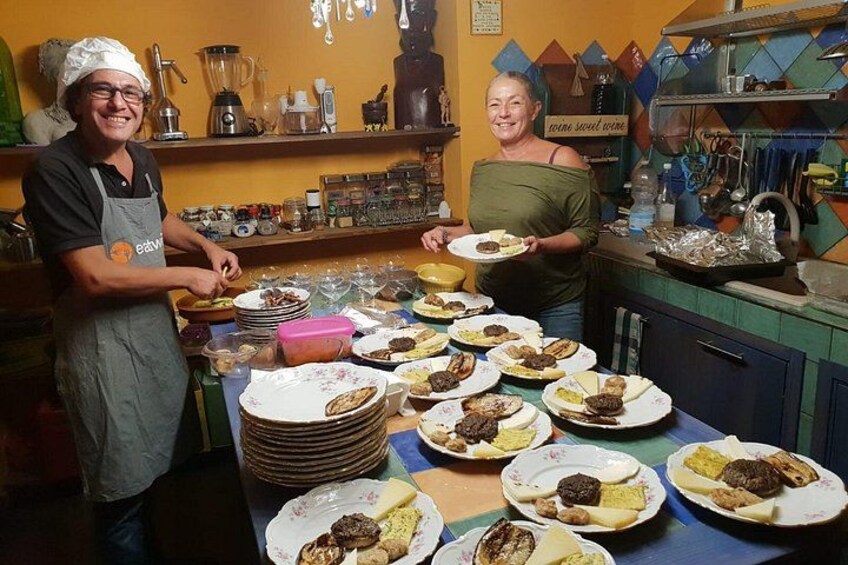 Una cocina con chefs preparando comida, una mesa con platos de comida y utensilios de cocina. 4