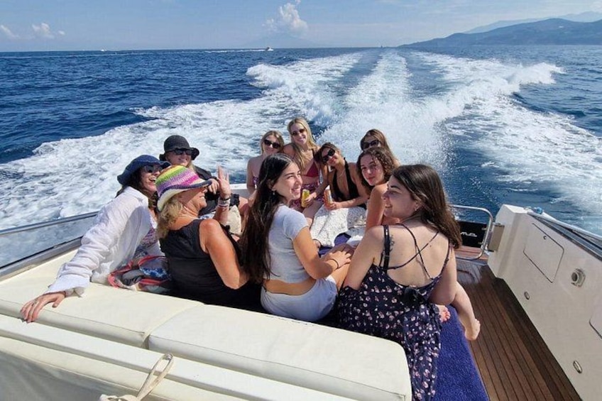 A group of people on a boat with the ocean and waves in the background. 5