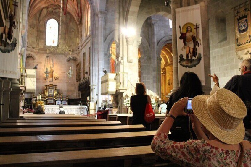 Interior de iglesia con techos altos, ventanas de arco y un altar central. 4