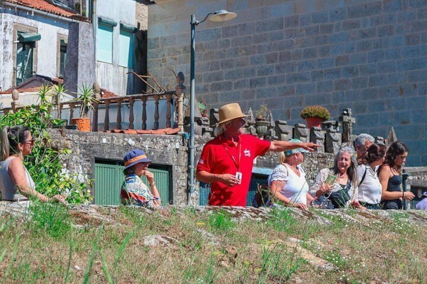 A group of people on a grassy slope with buildings in the background. 2