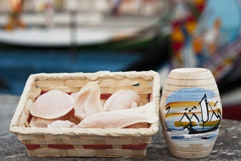 Un panier rempli de coquillages et un vase en céramique peint représentant une scène de marine. 5