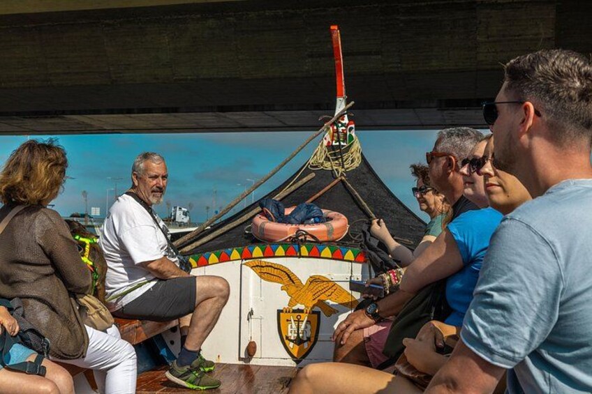 Un groupe de personnes se trouve sur un bateau dont la décoration est colorée et qui arbore un grand emblème représentant un aigle. 4