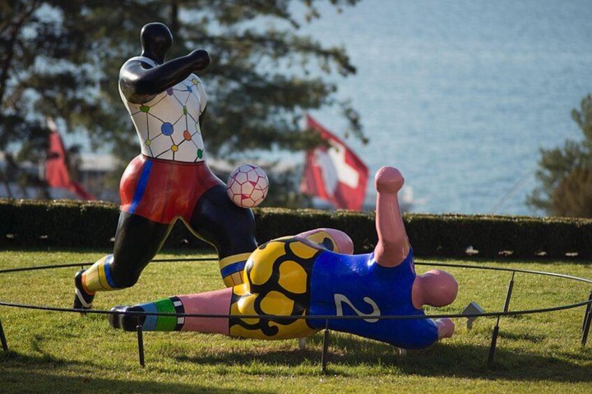 Une sculpture représentant un joueur de football en pleine action, un ballon de foot et un drapeau. 5