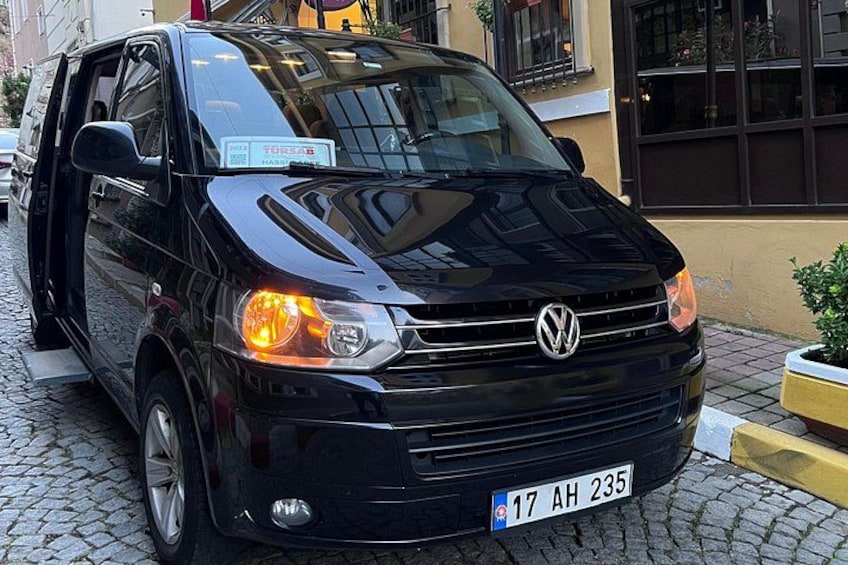 A black Volkswagen van parked on a cobblestone street. 5
