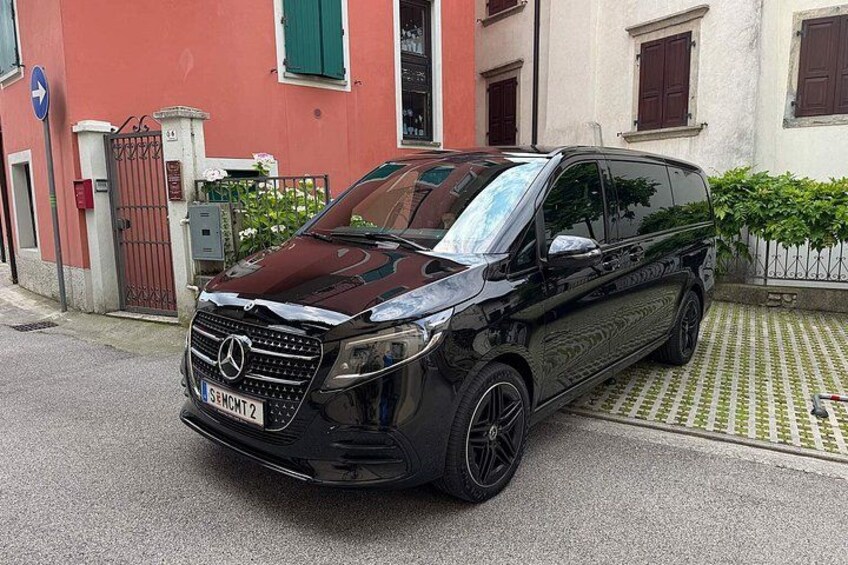 Ein schwarzer Mercedes-Benz Van parkt auf einer Straße, im Hintergrund ein rotes Gebäude. 5