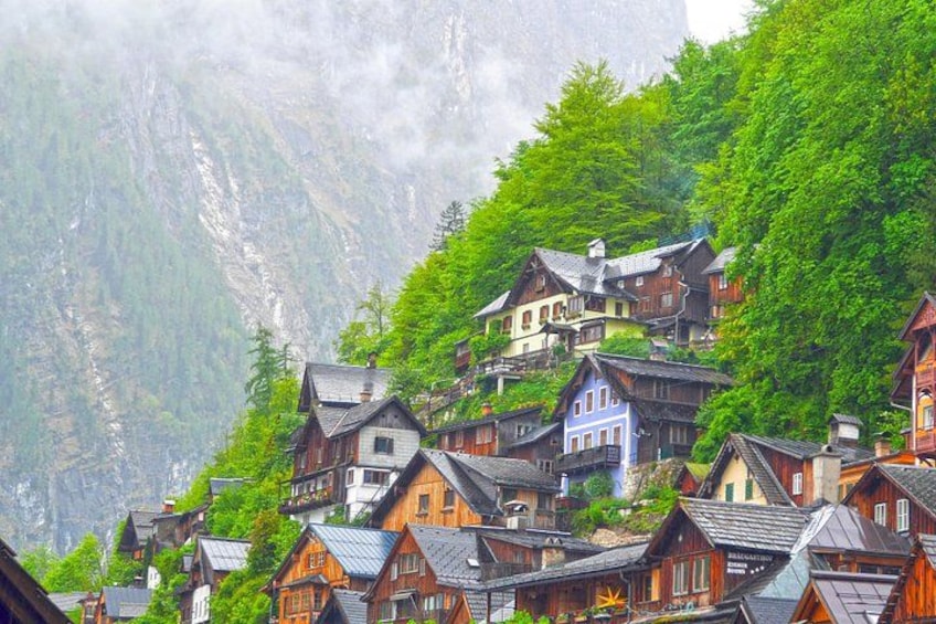 Un ensemble de maisons traditionnelles en bois, blotties au cœur d’une région montagneuse, au milieu d’une végétation luxuriante. 3