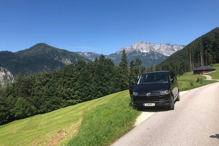 A black van parked on a rural road with a mountainous landscape in the background. 5