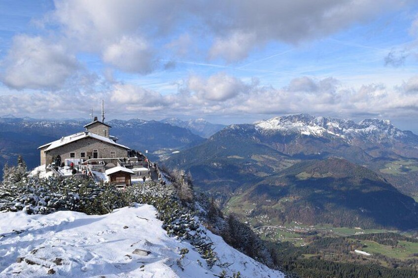 Une montagne enneigée, avec un chalet et une vue panoramique sur les Alpes. 1