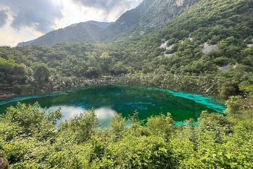 A turquoise lake surrounded by lush green mountains. 5