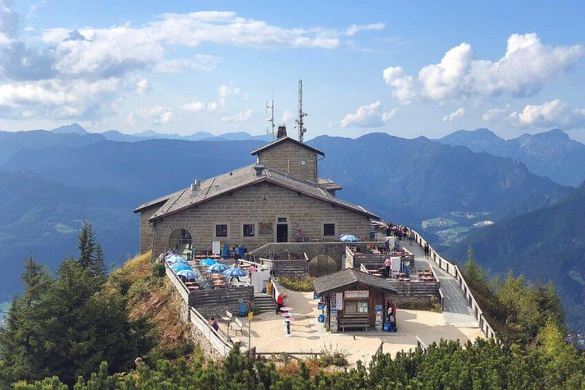 A mountain lodge with a terrace and a view of the surrounding mountains. 1