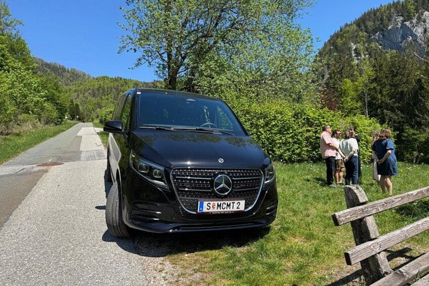 A black Mercedes-Benz SUV parked on a road with a scenic mountainous backdrop. 4