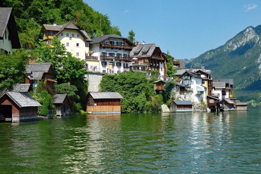 A lakeside village with traditional wooden houses and a mountain backdrop. 2