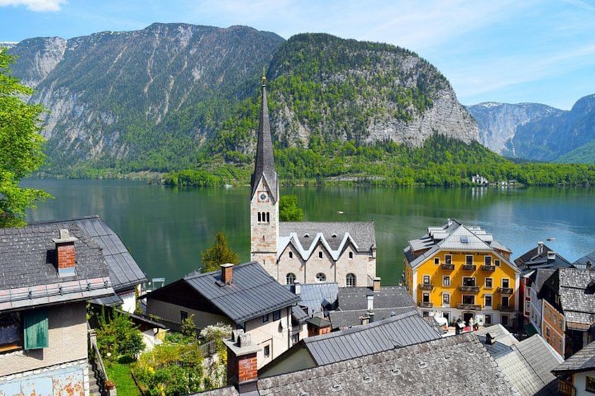 A town with a church, a lake, and mountains in the background. 1