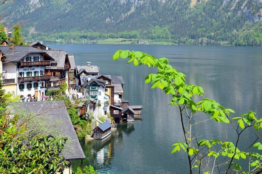 A lakeside village with traditional buildings, a dock, and a mountain backdrop. 3