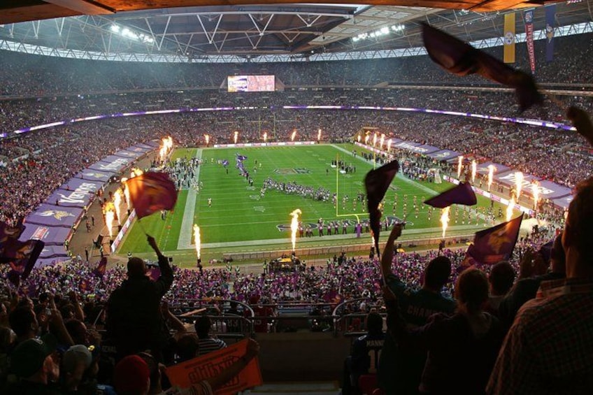 A stadium filled with spectators, a football field, and a large crowd. 5