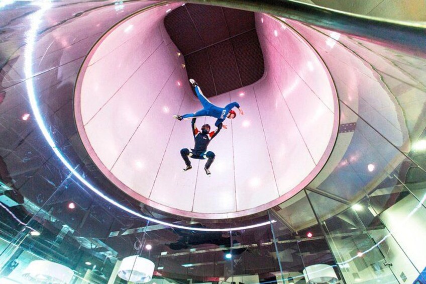 Una persona esegue un acrobatico aereo all'interno di una grande struttura circolare con interni metallici. 2