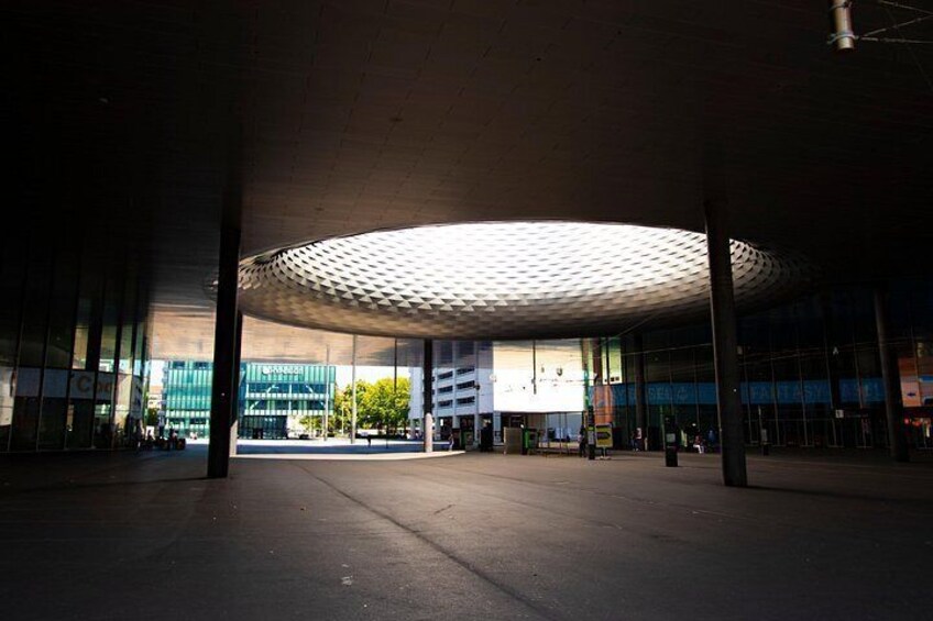 Un edificio moderno vacío con un techo curvo distintivo y ventanas amplias. 3