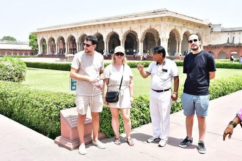 Un grupo de personas frente a un edificio histórico con arcos. 3