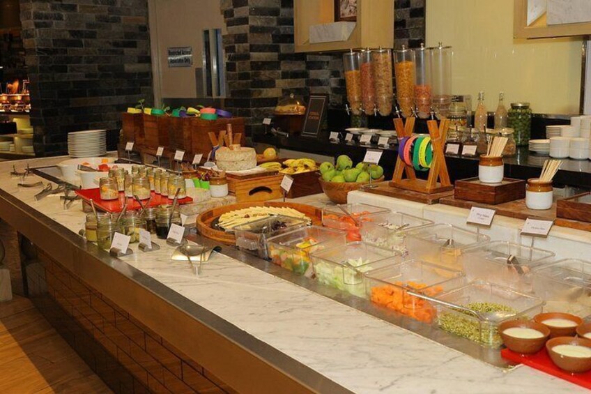 Un bufé con diferentes opciones de comida y recipientes. 3