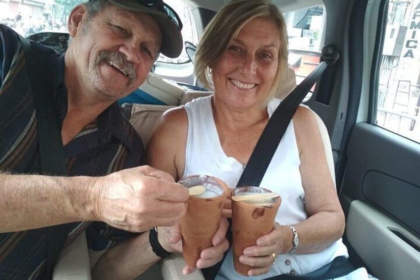 Dos personas en un auto, sosteniendo bebidas heladas. 4