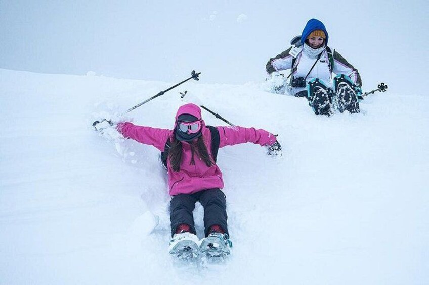 To personer står på ski ned ad en sneklædt skråning. 5