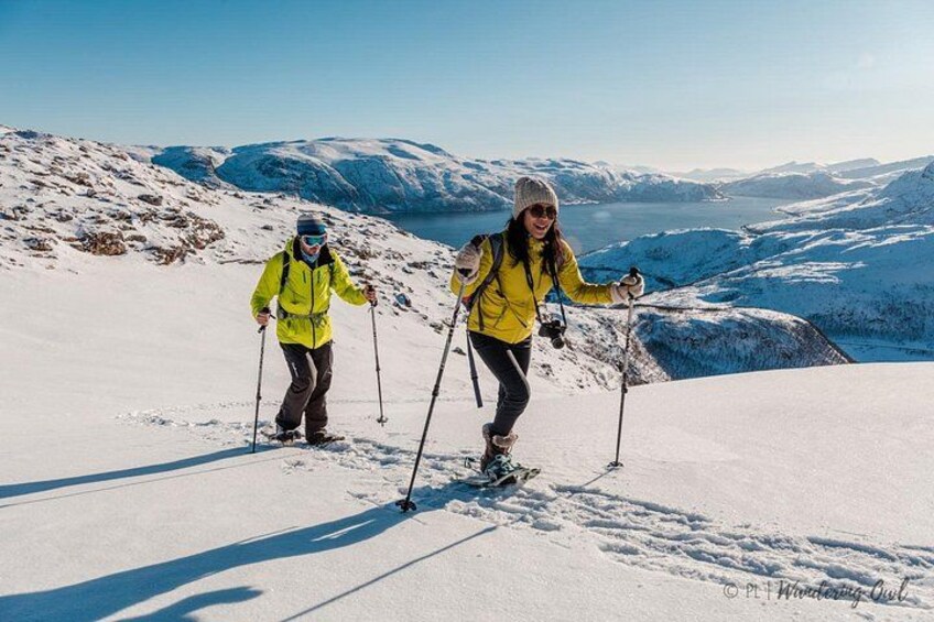 Zwei Personen fahren auf einem verschneiten Berg, der bewölkt ist. 3