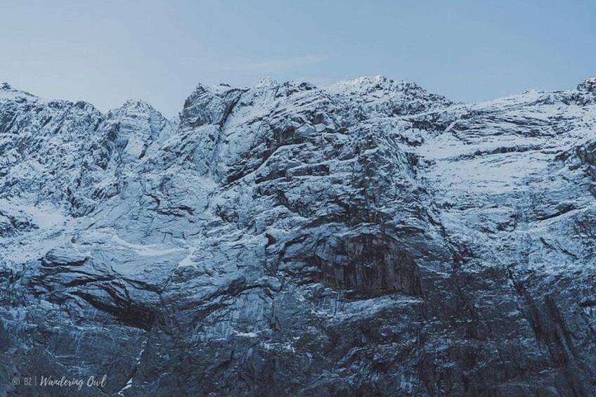 A snow-covered mountain range with rugged terrain and rocky outcrops. 2
