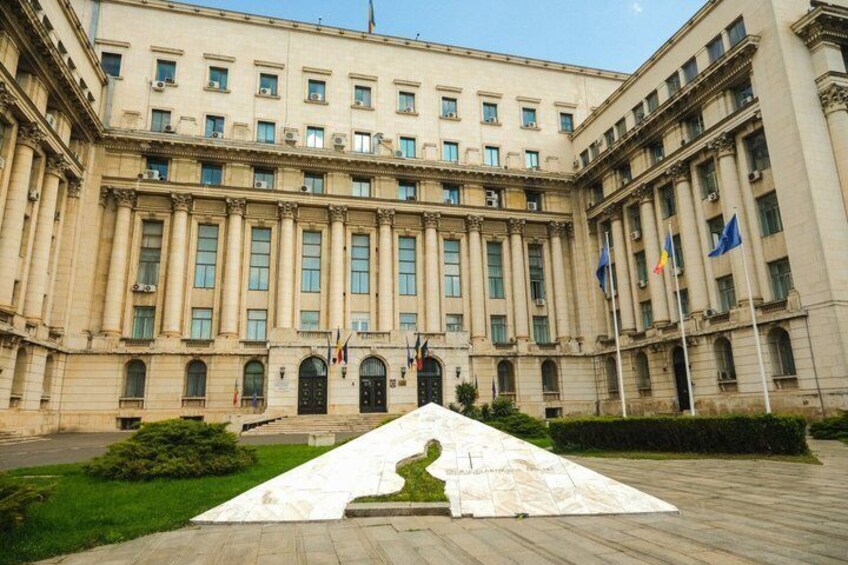 A large classical building with columns, flags, and a central entrance. 3