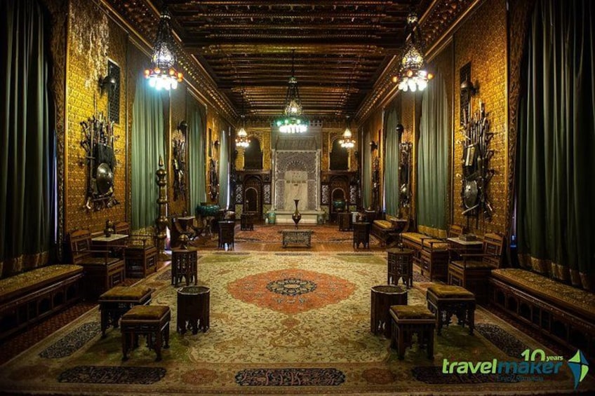 A grand hall with ornate chandeliers, a patterned carpet, and traditional furniture. 4