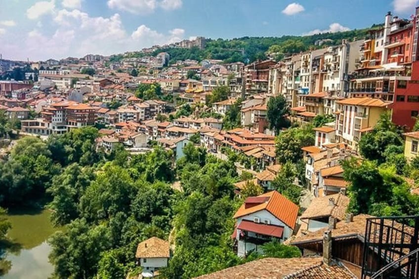 A densely built urban area with a river, surrounded by greenery and hills. 1