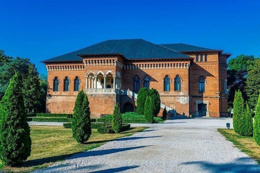 A large brick building with a symmetrical facade, arched windows, and a central entrance. 2