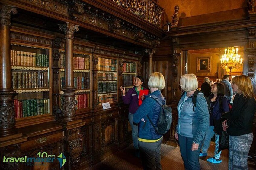 A library interior with wooden bookshelves and visitors. 2