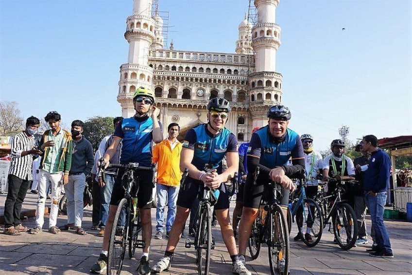 Eine Gruppe Radfahrer vor einem historischen Gebäude mit zwei Minaretten. 4