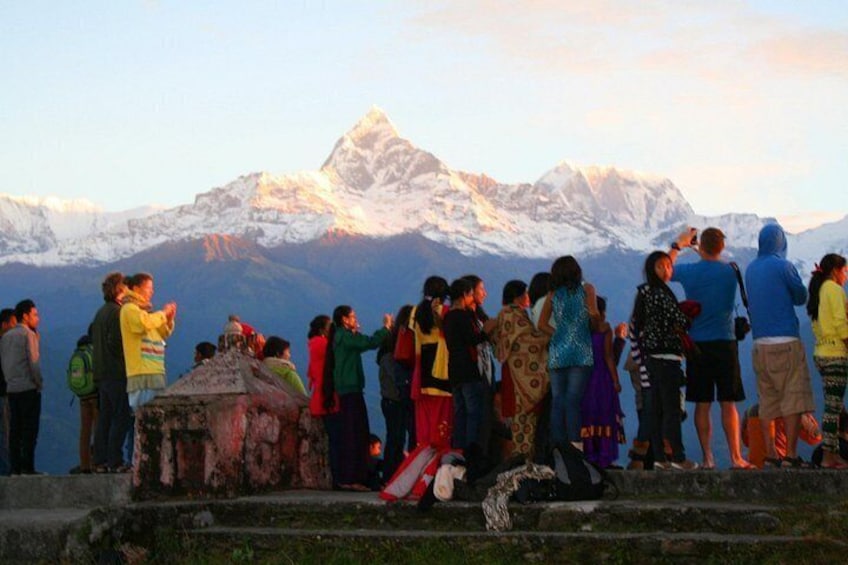 Un grupo de personas en un saliente, con vistas a una cadena montañosa. 1