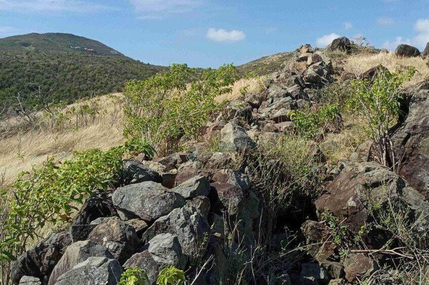 Une colline rocheuse, à la végétation clairsemée, avec une autre colline visible au loin. 2