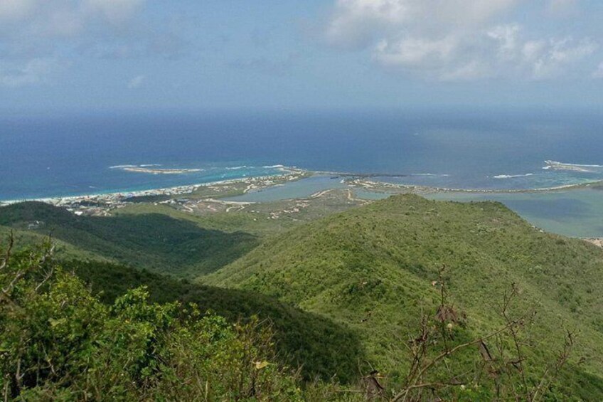 Un paysage côtier avec des collines, une plage et une île au loin. 3