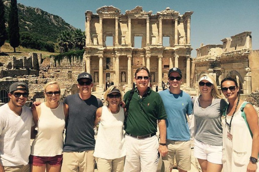 A group of people standing in front of the ancient ruins of the Library of Celsus in Ephesus. 1