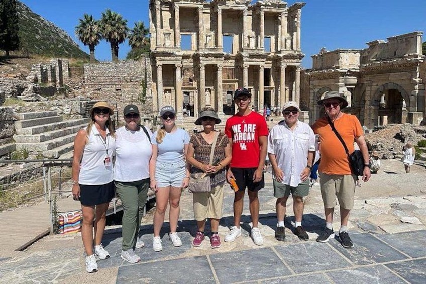 A group of people standing in front of ancient ruins with columns and steps. 5
