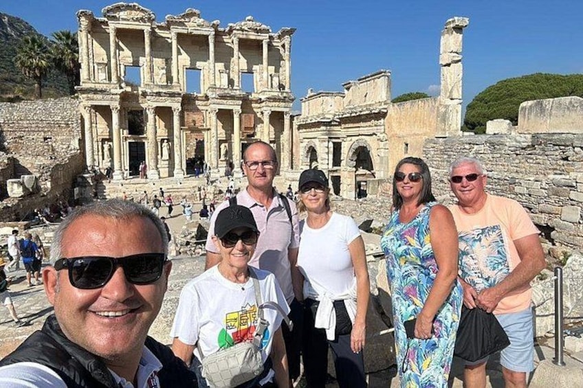 A group of people standing in front of ancient ruins with columns and arches. 4