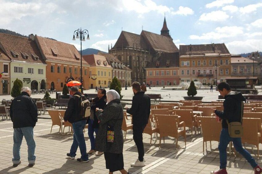 A public square with people, outdoor seating, and historic buildings. 2