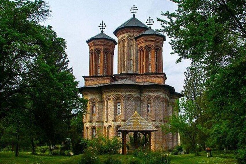 A historic church with two domes, surrounded by lush greenery. 4