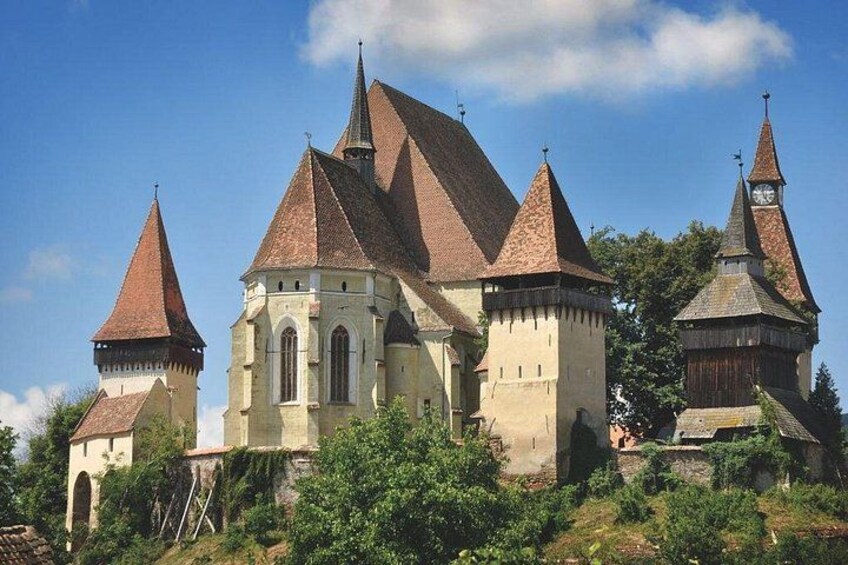 A historic building with multiple pointed towers and a central structure with arched windows. 5