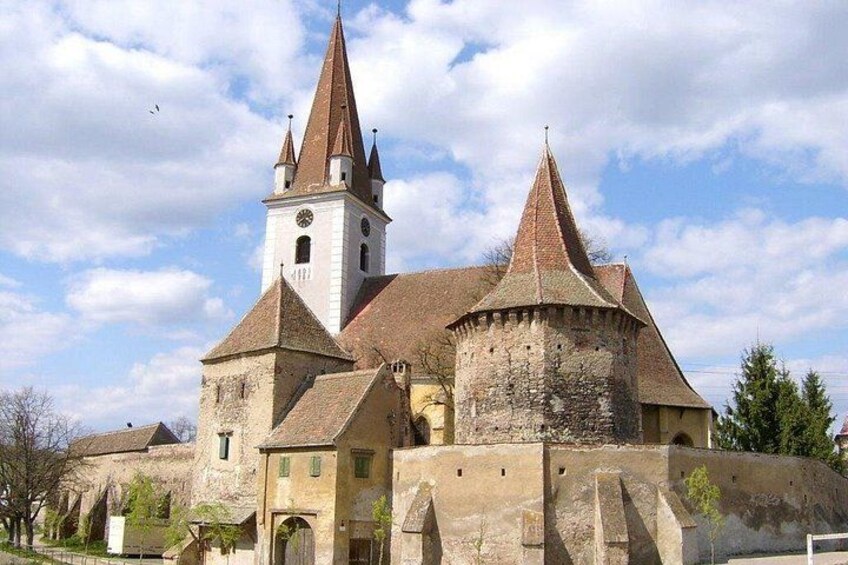 A historic church with a bell tower and a round tower. 1
