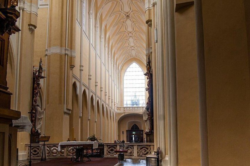 Interno di una cattedrale con soffitti a volta alta, finestre ad arco e una navata centrale che conduce a un altare. 2