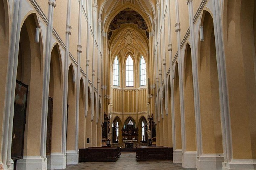 A cathedral interior with arched ceilings, tall columns, and a central altar. 2