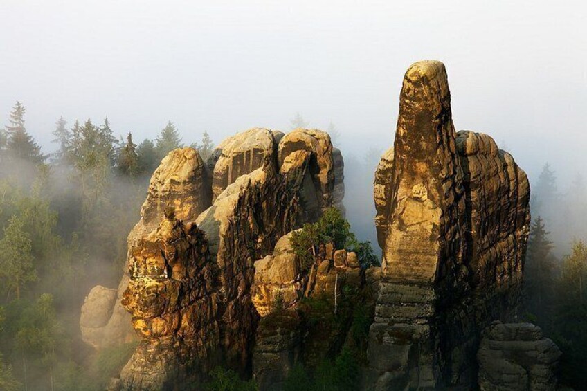 Una formación rocosa con un pilar vertical destacado y una serie de grandes rocas redondeadas. 3