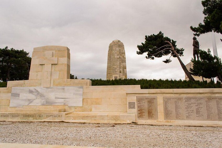 A memorial with inscriptions, a tall obelisk, and a statue of a person. 2