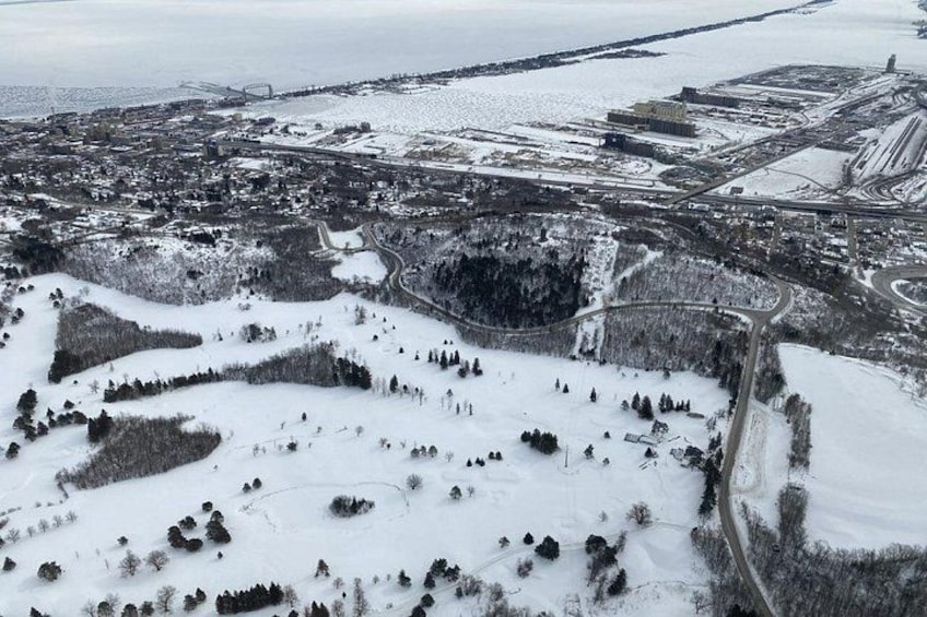 Et snøklædt landskab med en by, veje og en bro i baggrunden. 3